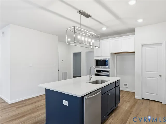 a kitchen with a sink a microwave and cabinets