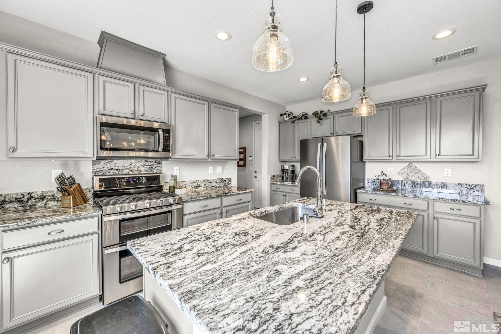 2265 Selway Drive Sparks, NV 89436 - Photo 12 of 39 a kitchen with stainless steel appliances granite countertop a stove top oven a refrigerator a sink and a stove