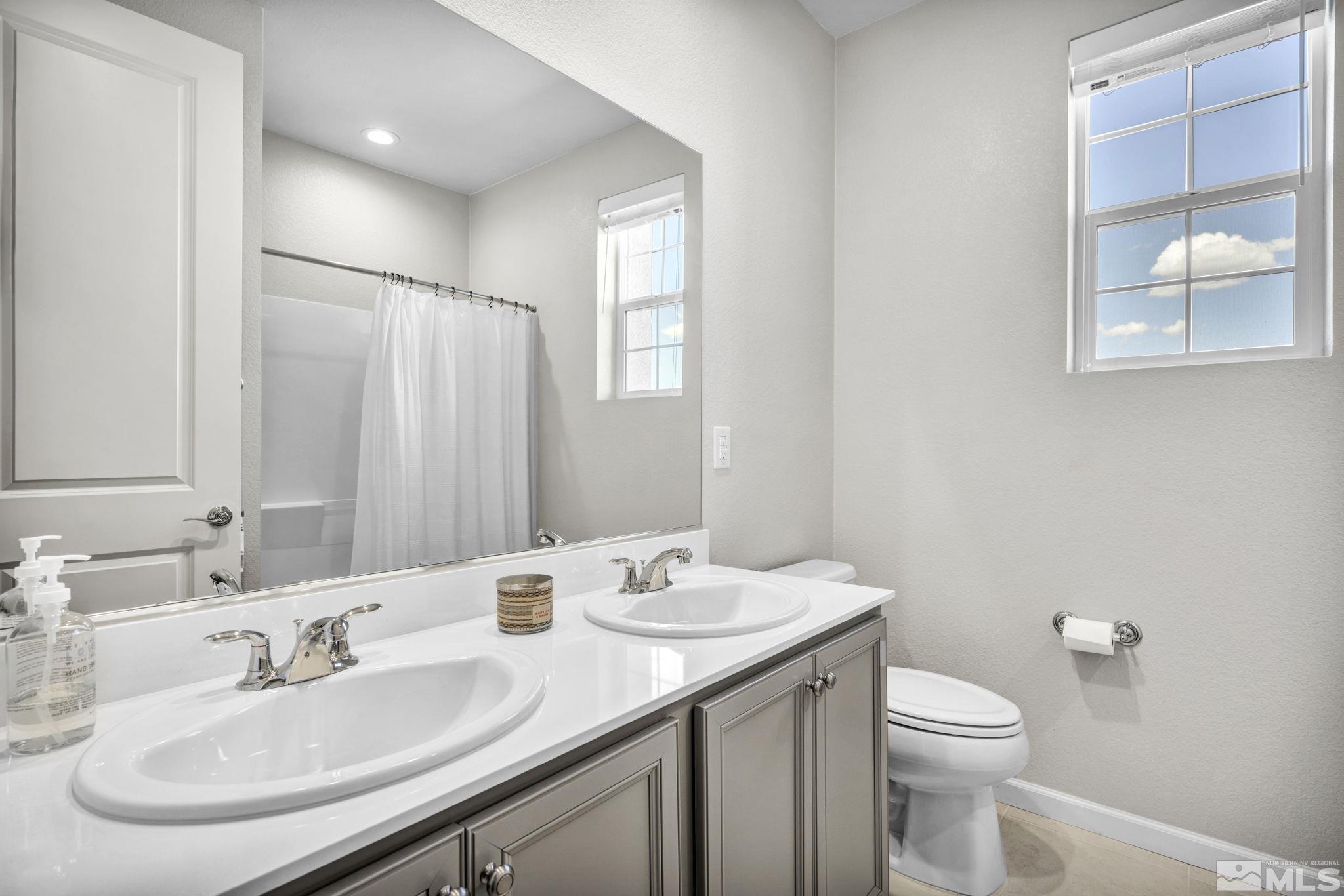 2265 Selway Drive Sparks, NV 89436 - Photo 27 of 39 a bathroom with a granite countertop sink toilet and large mirror
