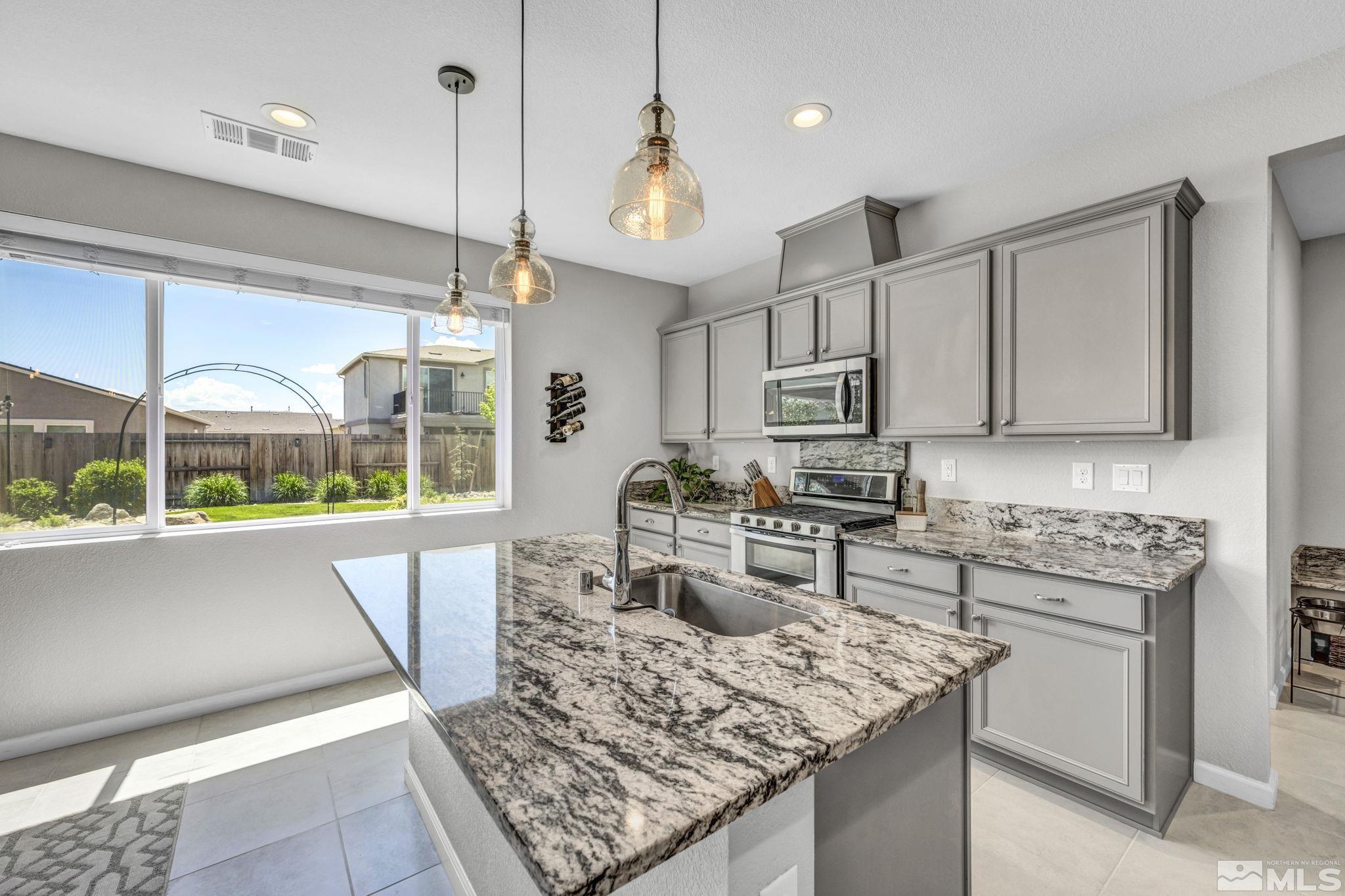 2265 Selway Drive Sparks, NV 89436 - Photo 9 of 39 a kitchen with stainless steel appliances granite countertop a stove a sink and a wooden cabinets