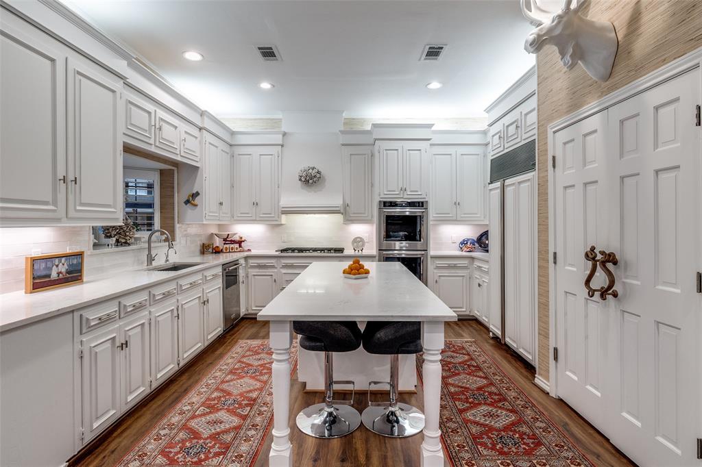 5723 Overdowns Drive Dallas, TX 75230 - Photo 14 of 36 a kitchen with white cabinets and stainless steel appliances