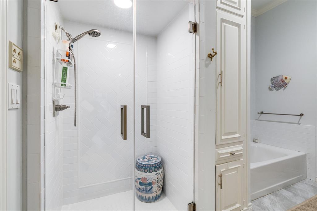5723 Overdowns Drive Dallas, TX 75230 - Photo 27 of 36 a bathroom with a tub and a shower
