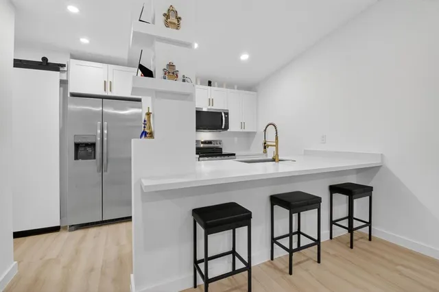 a kitchen with stainless steel appliances a sink cabinets and refrigerator
