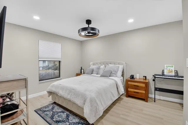 a bedroom with a bed and a flat tv screen on the dresser