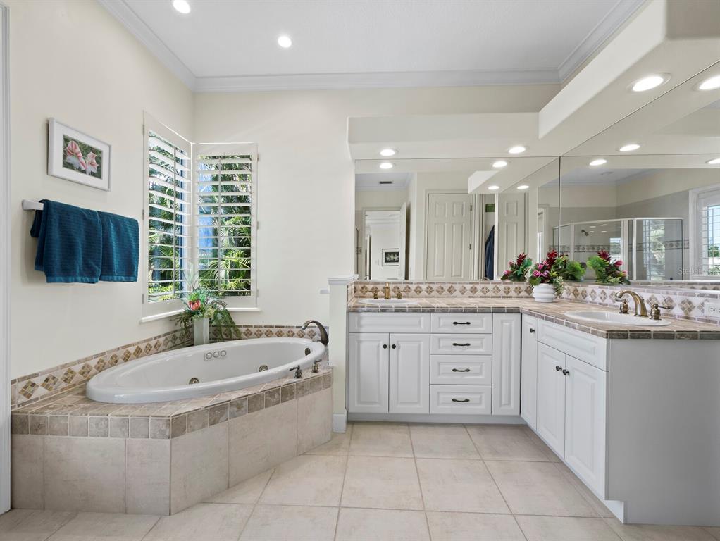 573 Spinnaker Lane Longboat Key, FL 34228 - Photo 13 of 43 a bathroom with a granite countertop tub sink and mirror