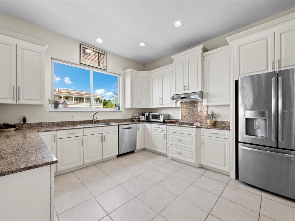 573 Spinnaker Lane Longboat Key, FL 34228 - Photo 16 of 43 a kitchen with stainless steel appliances granite countertop a refrigerator sink and cabinets