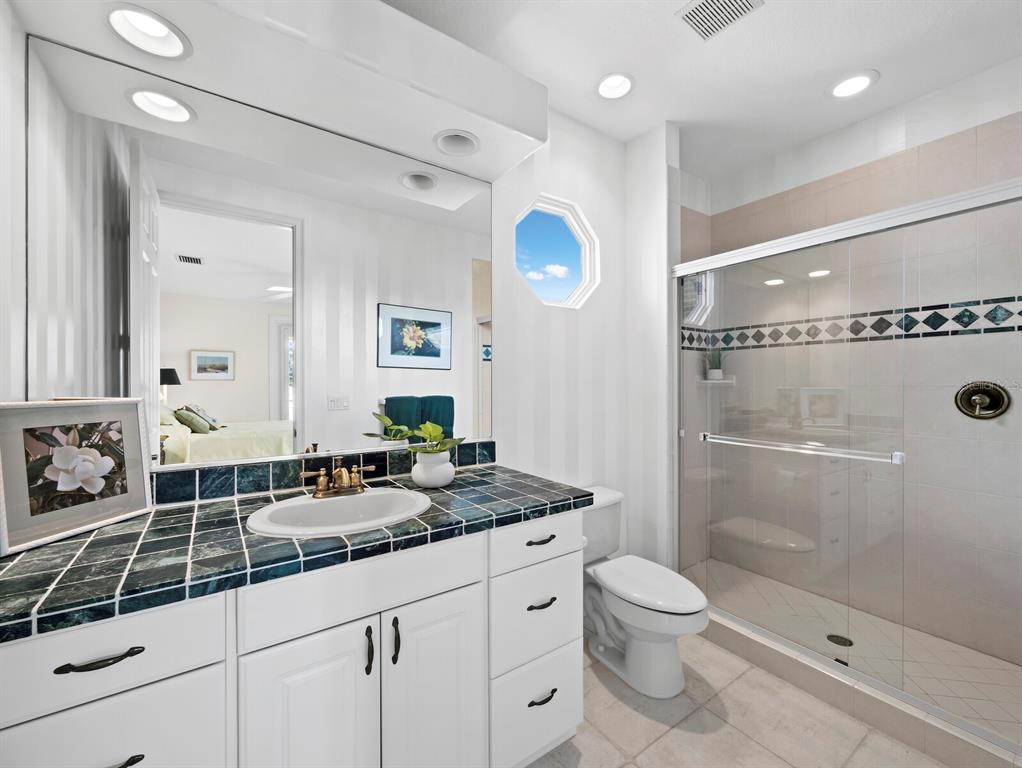 573 Spinnaker Lane Longboat Key, FL 34228 - Photo 21 of 43 a bathroom with a granite countertop sink a toilet a mirror and shower