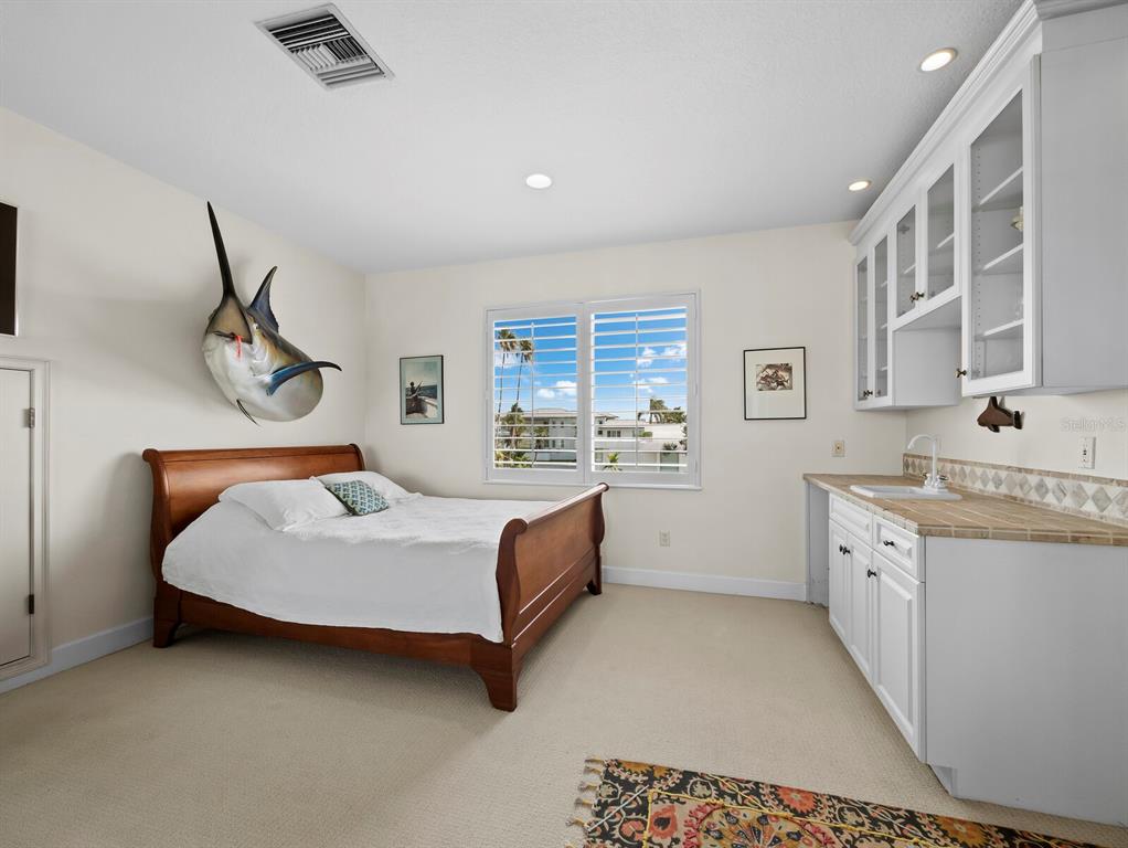 573 Spinnaker Lane Longboat Key, FL 34228 - Photo 25 of 43 a spacious bedroom with a bed and a chandelier