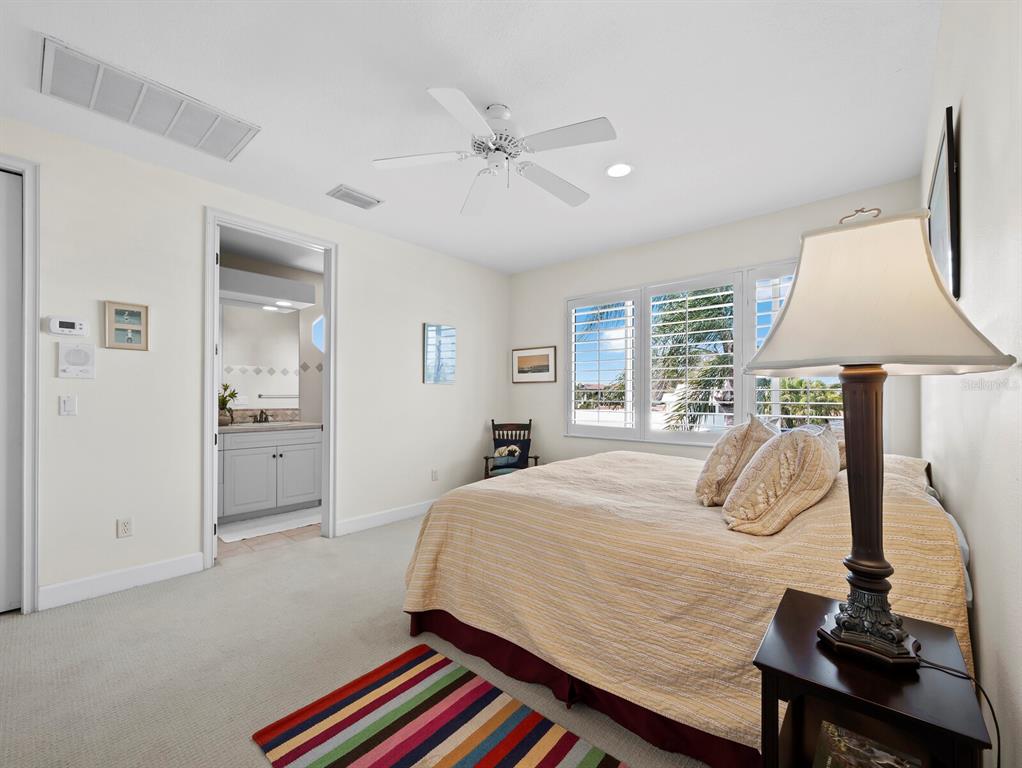 573 Spinnaker Lane Longboat Key, FL 34228 - Photo 27 of 43 a bedroom with a bed and a lamp with window