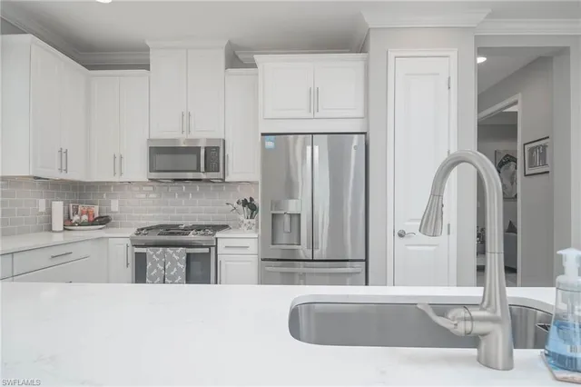 a kitchen with stainless steel appliances granite countertop a refrigerator and a stove top oven