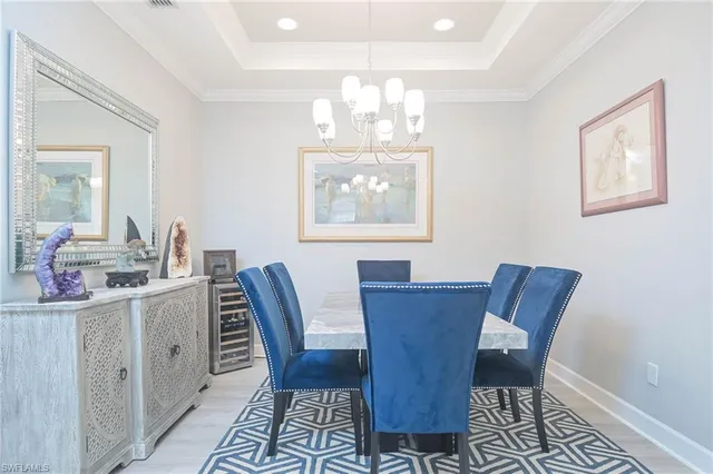 a view of a dining room with furniture a chandelier and wooden floor