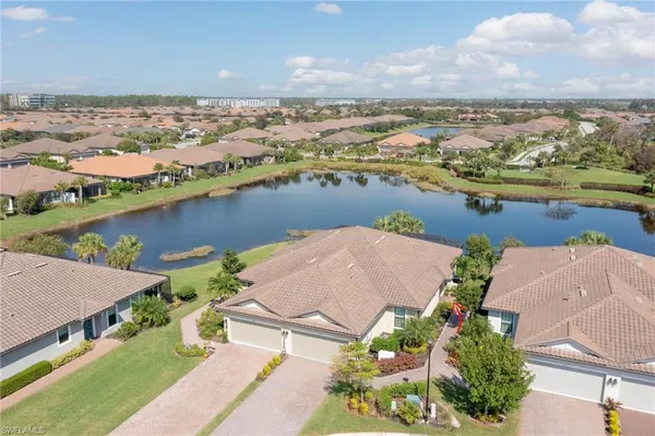 an aerial view of residential houses with outdoor space and lake view