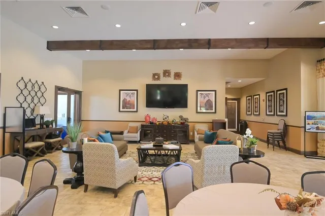a living room with furniture kitchen view and a flat screen tv