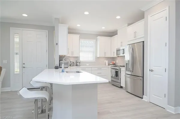 a kitchen with a refrigerator a sink and cabinets