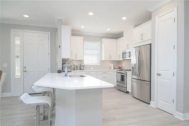 a kitchen with a refrigerator a sink and cabinets