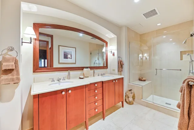 a en suite bathroom with a double vanity sink and a mirror