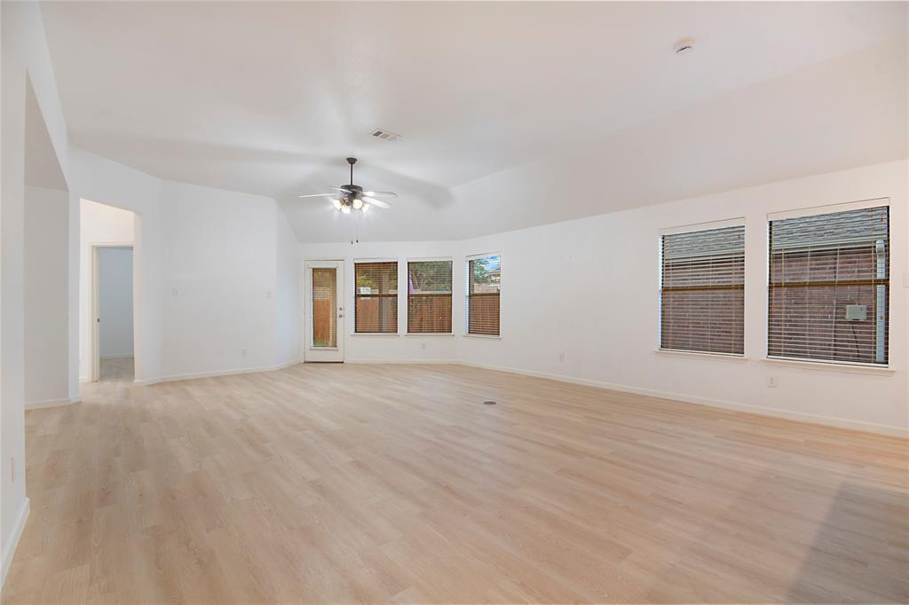 549 Hickory Lane Fate, TX 75087 - Photo 11 of 38 Empty room featuring ceiling fan, light wood-style floors, and lofted ceiling