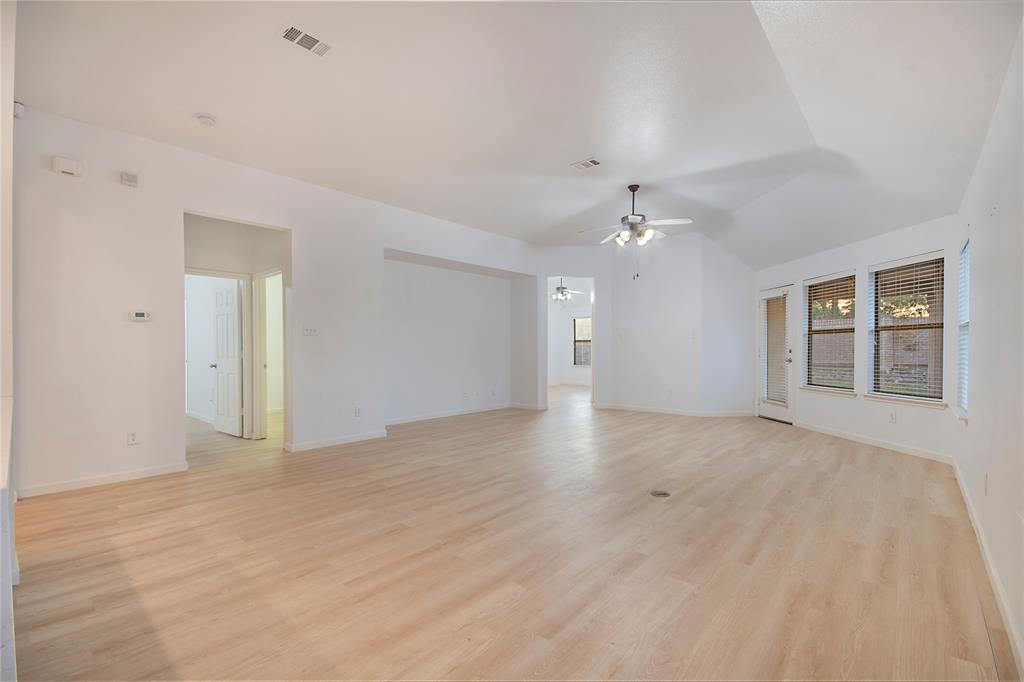 549 Hickory Lane Fate, TX 75087 - Photo 13 of 38 Empty room with light wood finished floors, ceiling fan, and lofted ceiling