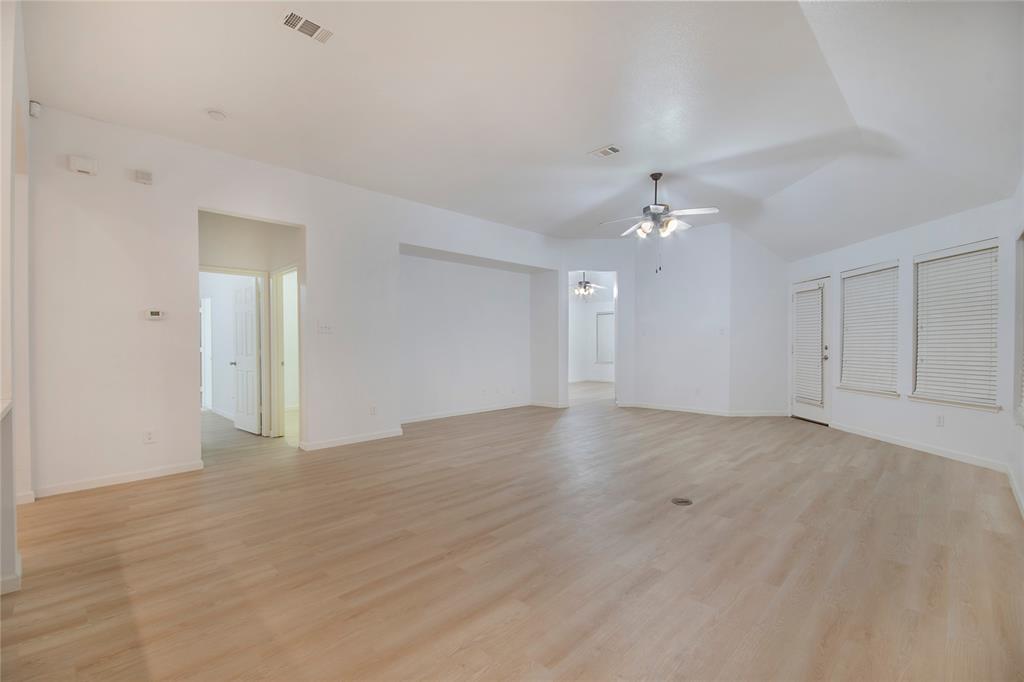 549 Hickory Lane Fate, TX 75087 - Photo 14 of 38 Unfurnished room with ceiling fan, light wood finished floors, and vaulted ceiling