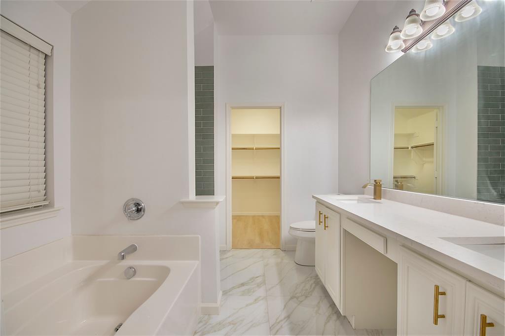 549 Hickory Lane Fate, TX 75087 - Photo 20 of 38 Full bathroom with a walk in closet, double vanity, a bath, and light marble finish flooring
