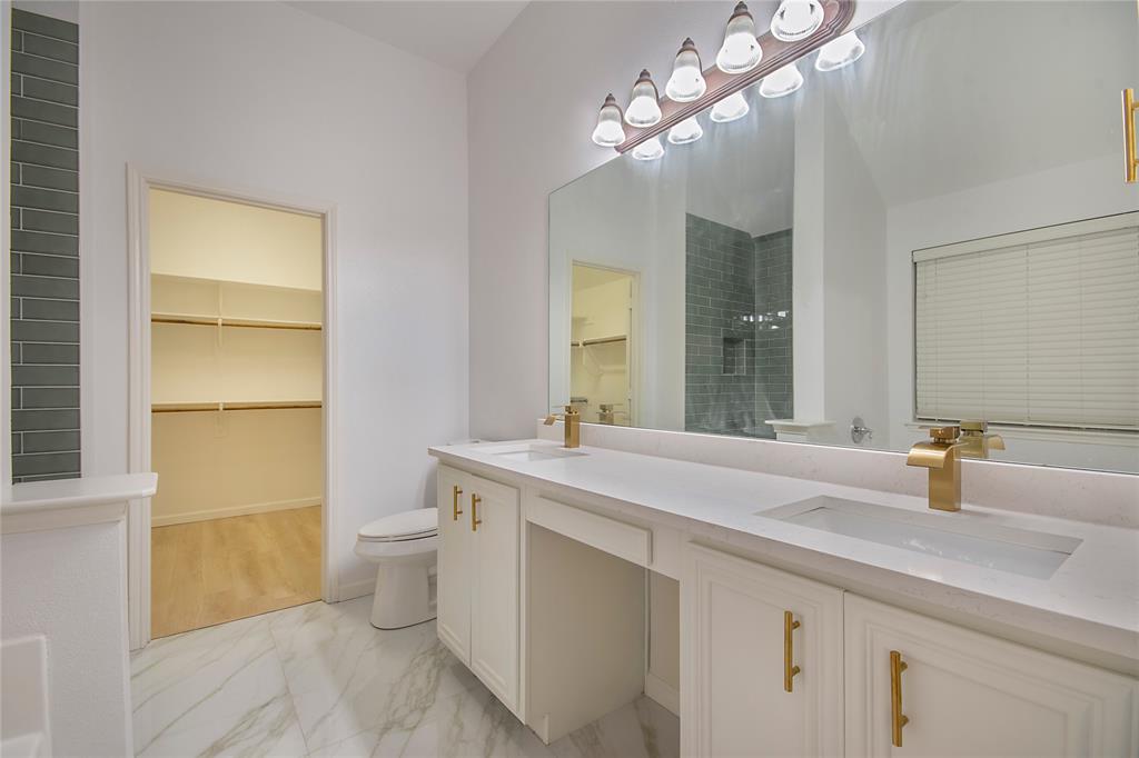 549 Hickory Lane Fate, TX 75087 - Photo 21 of 38 Bathroom with a spacious closet, double vanity, light marble finish flooring, and a stall shower