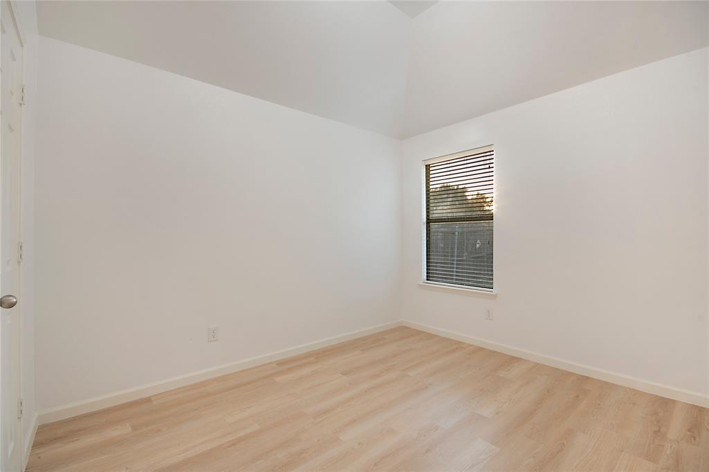 549 Hickory Lane Fate, TX 75087 - Photo 26 of 38 Empty room with light wood-type flooring and vaulted ceiling