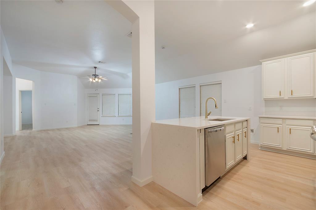 549 Hickory Lane Fate, TX 75087 - Photo 8 of 38 Kitchen with a center island with sink, light wood-type flooring, white cabinets, stainless steel dishwasher, and a ceiling fan