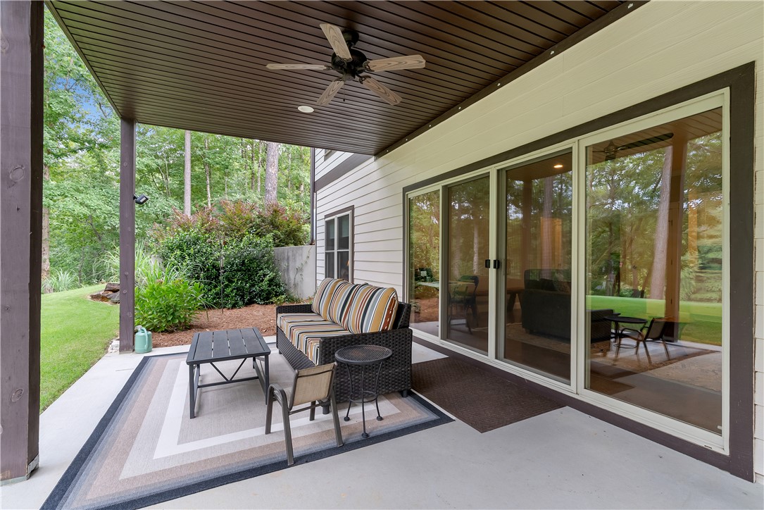329 High Hampton Road Salem, SC 29676 - Photo 37 of 47 Sliding glass doors open onto a sheltered concrete patio overlooking a grassy backyard.
