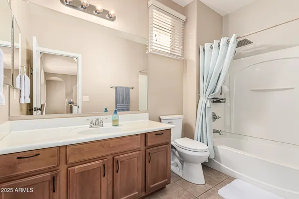 a bathroom with a sink a toilet and a large mirror