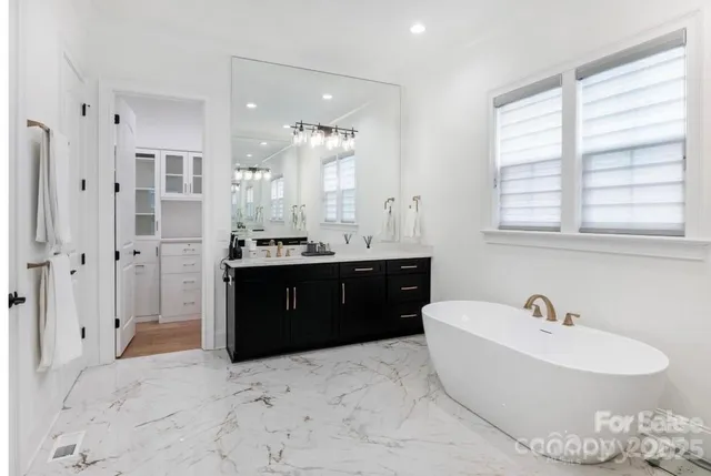 a spacious bathroom with a tub sink double vanity and shower
