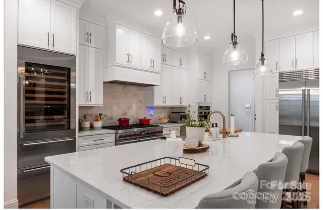 a kitchen with kitchen island granite countertop a sink a stove and a refrigerator