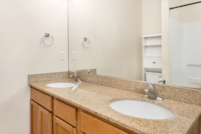 a bathroom with a granite countertop sink and a mirror