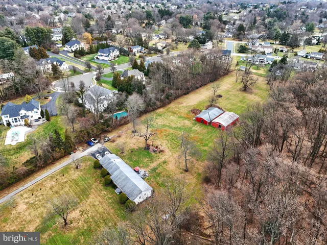 an aerial view of residential houses with outdoor space and trees