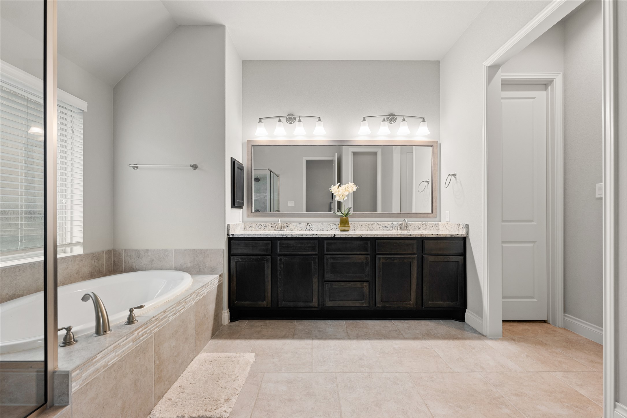 4103 August Light Court Fulshear, TX 77441 - Photo 14 of 33 a bathroom with a tub a double vanity sink and a mirror