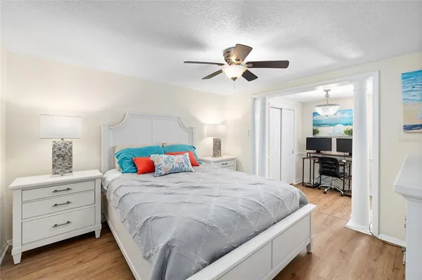 a bedroom with a bed and a flat screen tv in white walls