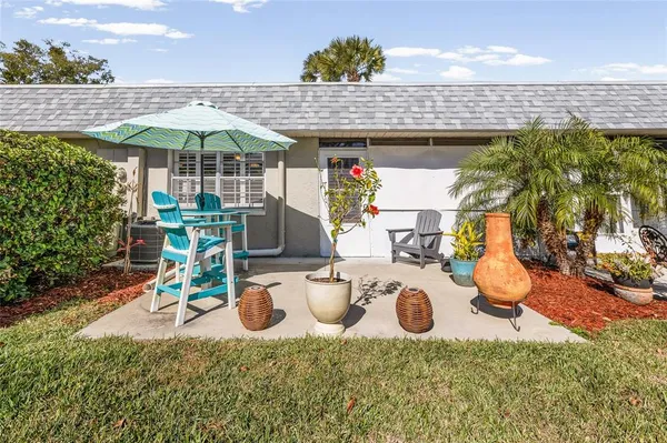 a view of a patio with table and chairs under an umbrella