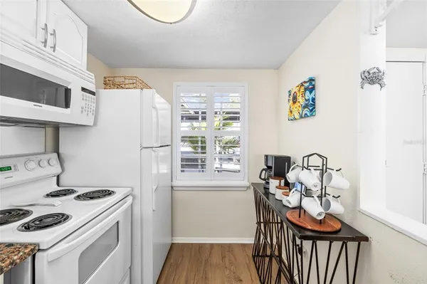 a kitchen with stainless steel appliances granite countertop a sink a stove a refrigerator and island with wooden floor