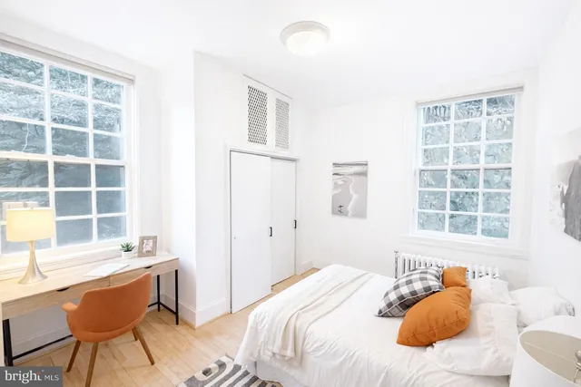 a bedroom with a bed and a lamp with the dresser