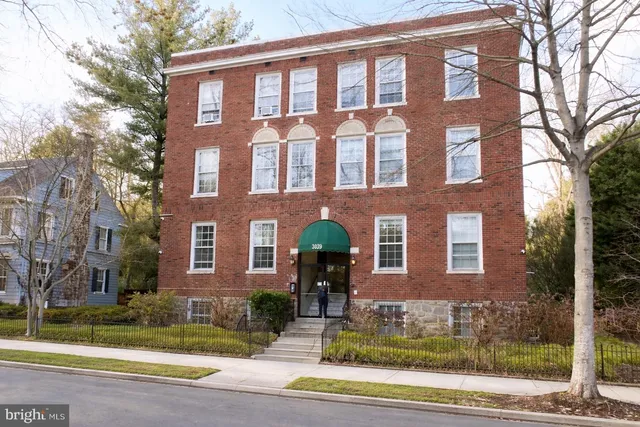 front view of a brick house with a yard