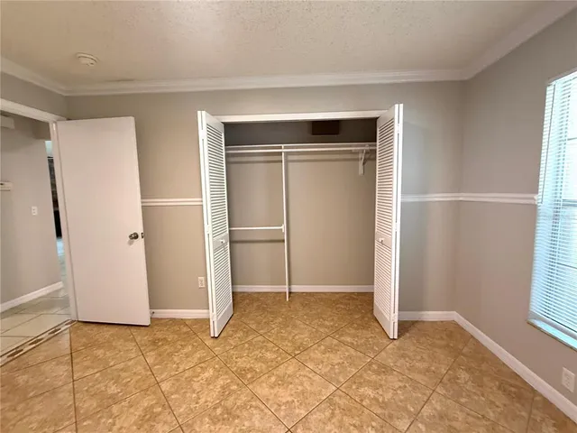 an empty room with closet and windows