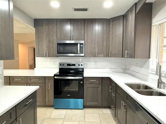 a kitchen with a sink stove and microwave