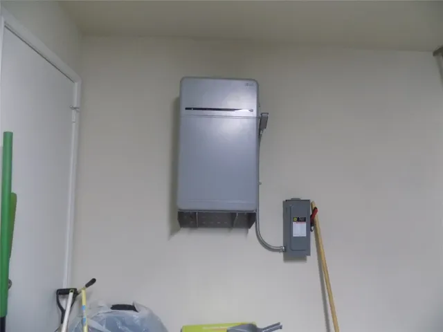 a water heater room with a refrigerator