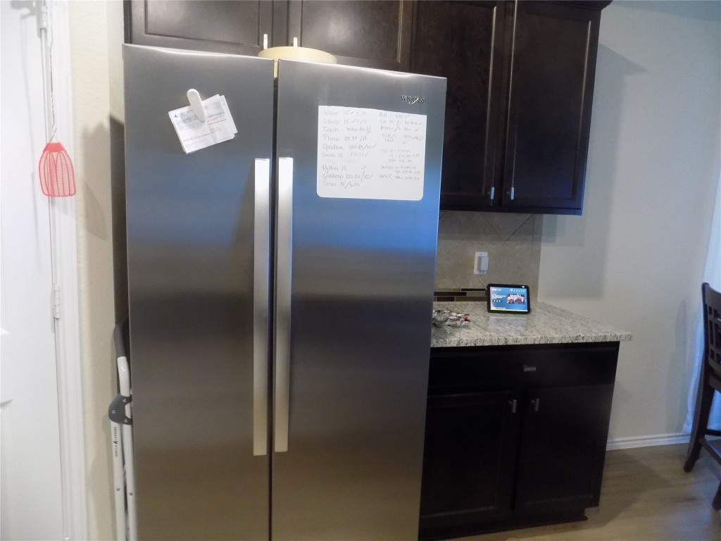 124 Rearden Boulevard Jarrell, TX 76537 - Photo 4 of 16 a kitchen with a refrigerator and cabinets