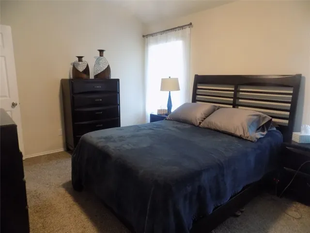 a bedroom with a bed and a dresser