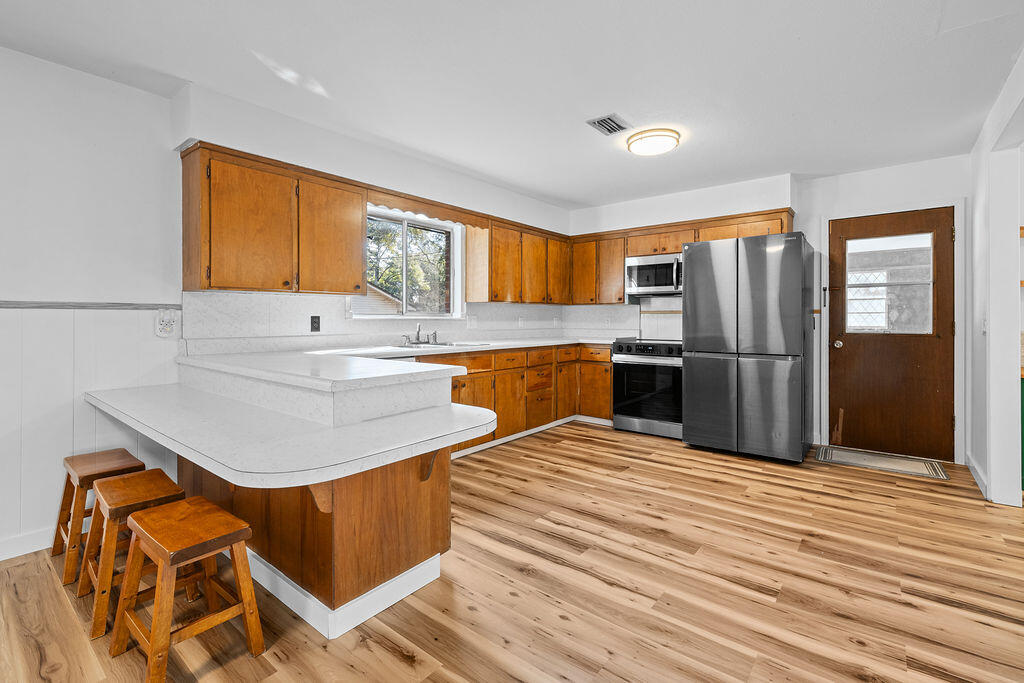 1623 18th Street Niceville, FL 32578 - Photo 11 of 41 a kitchen with stainless steel appliances granite countertop a refrigerator sink and cabinets