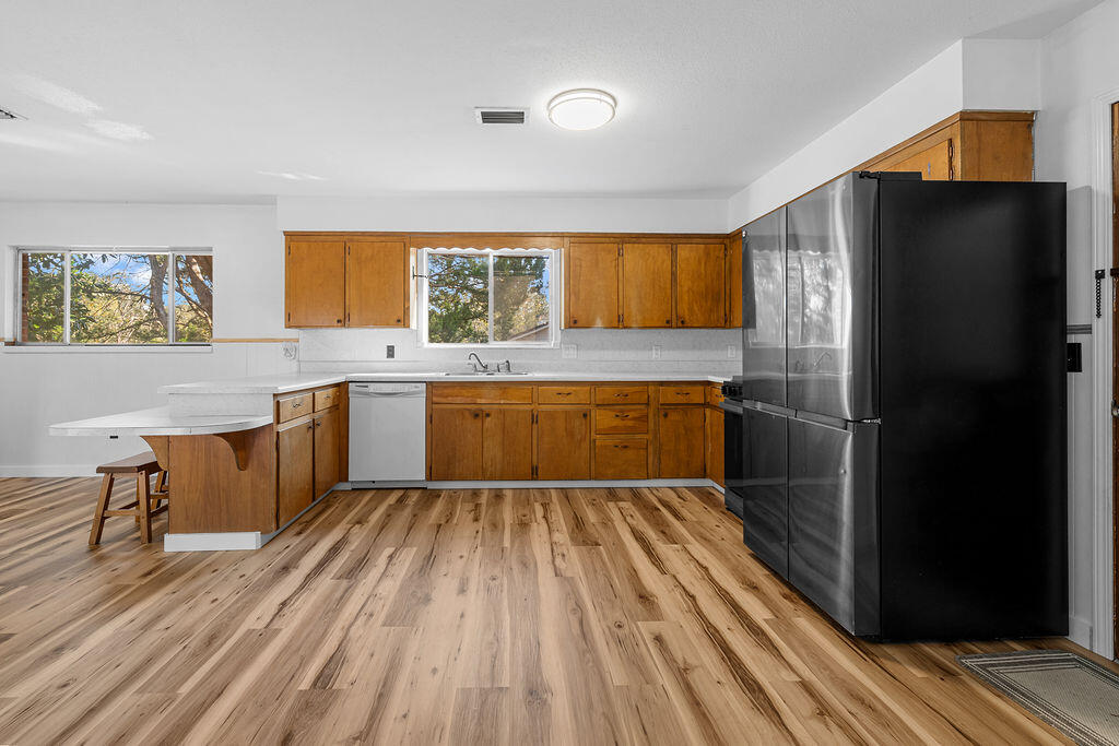 1623 18th Street Niceville, FL 32578 - Photo 8 of 41 a kitchen with a refrigerator and wooden cabinets