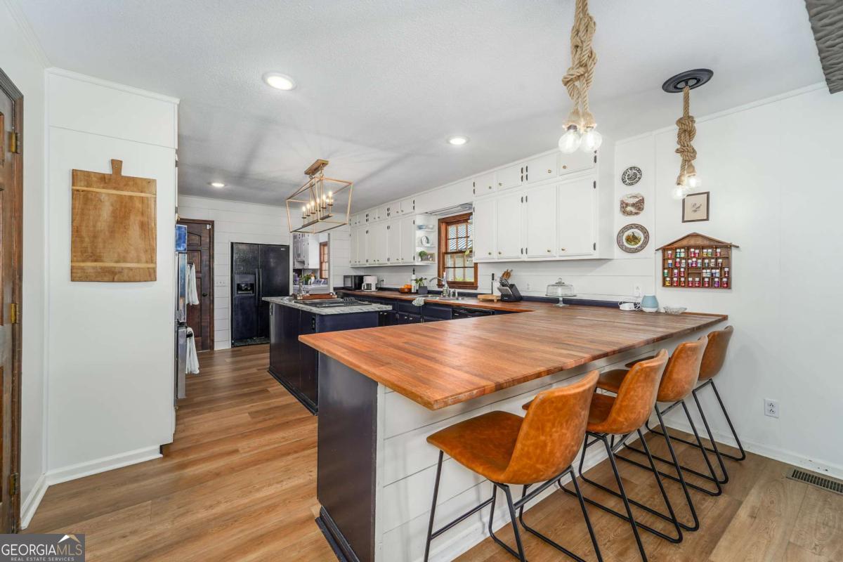403 Rose Lane Douglas, GA 31533 - Photo 22 of 42 a kitchen with stainless steel appliances kitchen island granite countertop a table chairs and a refrigerator