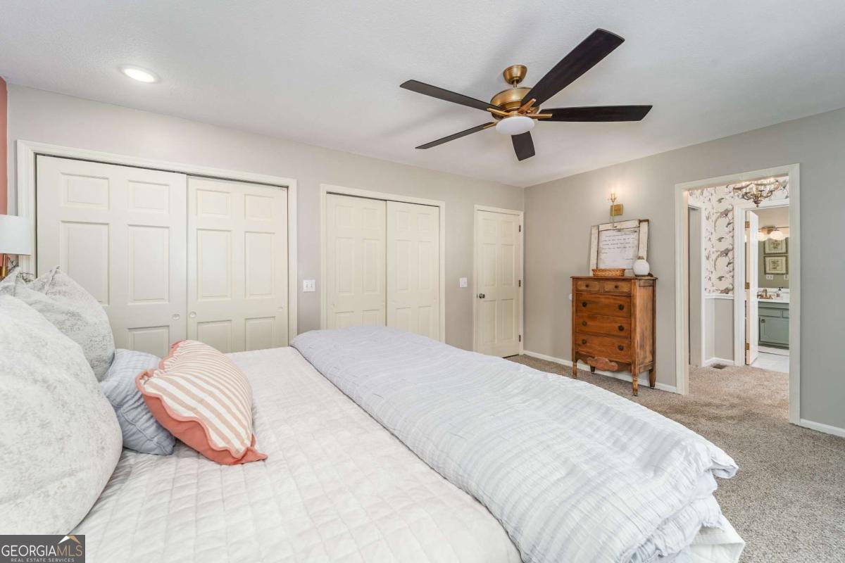 403 Rose Lane Douglas, GA 31533 - Photo 29 of 42 a bedroom with a large bed and a chandelier