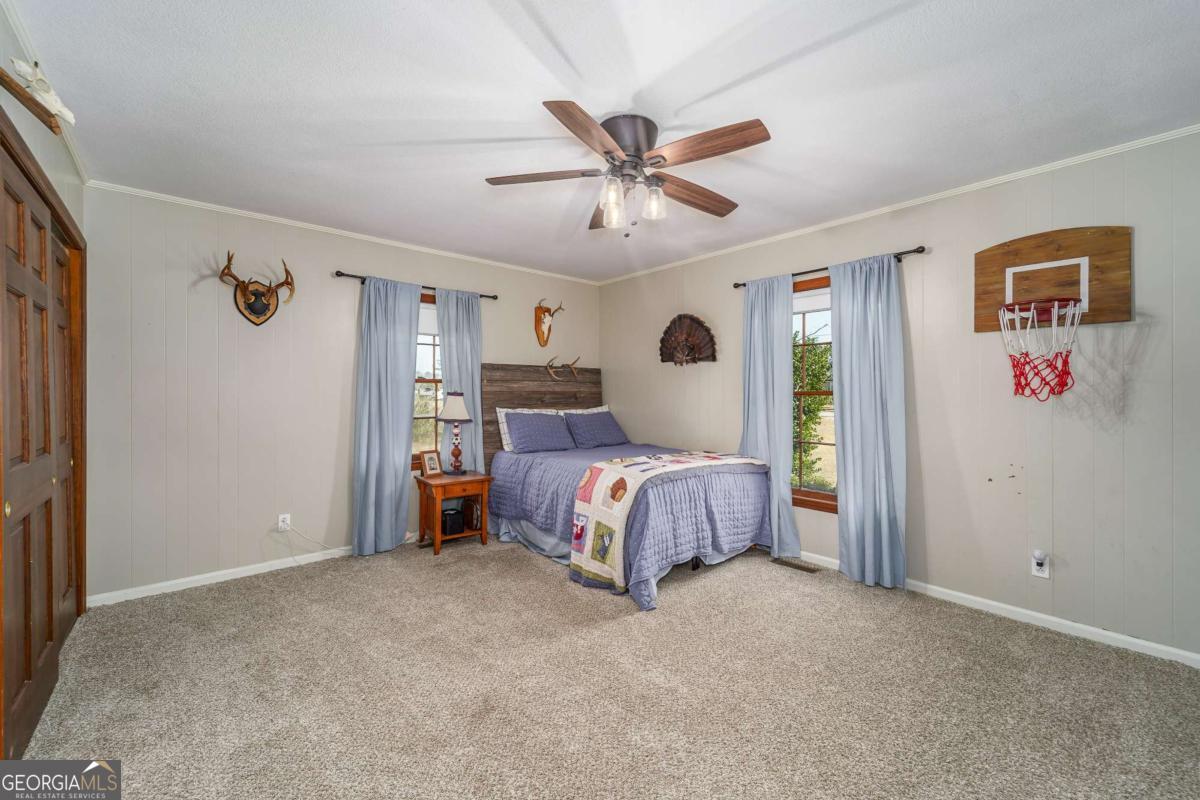 403 Rose Lane Douglas, GA 31533 - Photo 33 of 42 a spacious bedroom with a bed and a chandelier