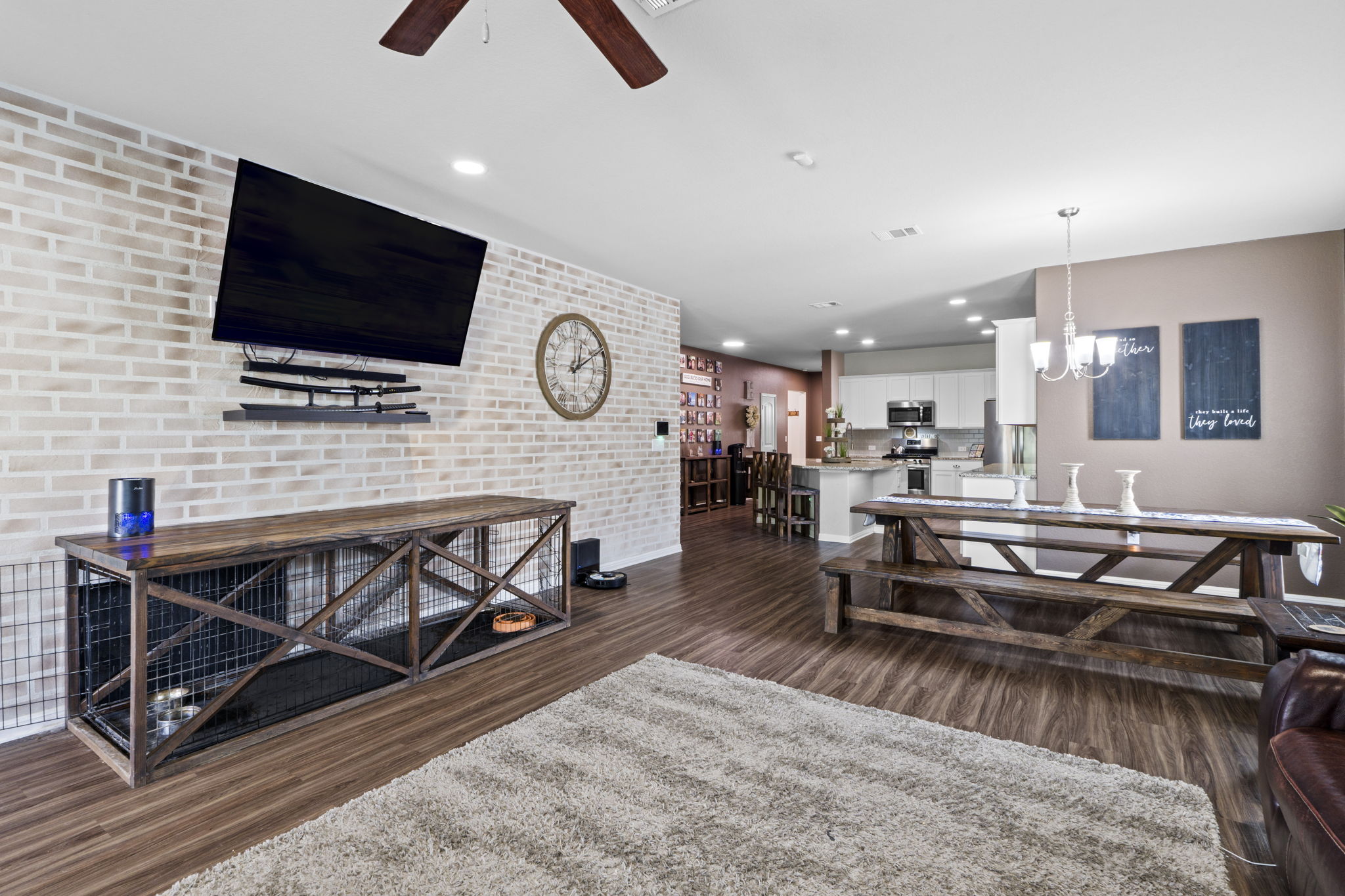 2417 Bridges Ranch Road Georgetown, TX 78628 - Photo 20 of 36 Living room with dark wood-style flooring, ceiling fan, hanging lights, and brick wall